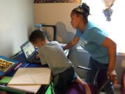 Tiffany Shelton helps her 7-year-old son, P.J. Shelton, a second-grader, during an online class at their home in Norristown, Pa., on Thursday, Sept. 3, 2020. Norristown Area School District plans to offer online-only instruction through at least January 2021.