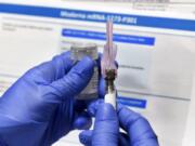 FILE - In this Monday, July 27, 2020 file photo, a nurse prepares a shot as a study of a possible COVID-19 vaccine, developed by the National Institutes of Health and Moderna Inc., gets underway in Binghamton, N.Y. On Tuesday, Sept. 8, 2020, the top executives of nine drugmakers likely to produce the first vaccines against the new coronavirus said that they will stick to the highest ethical and scientific standards in testing and manufacturing and will make the well-being of those getting vaccinated their top priority.