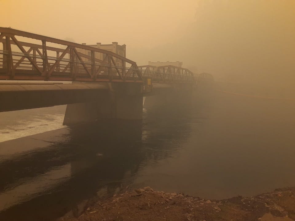 This Sept. 10, 2020, photo provided by Erik Withalm shows the roll gates on the Leaburg Dam opened to release water and drain the lake behind the dam during the Holiday Farm Fire east of Eugene, Oregon. The local utility opened the dams to prevent wildfire debris and downed trees from snagging on the gates, but the move deprived the nearby Leaburg Fish Hatchery of fresh water. The hatchery was forced to release more than 1 million steelhead, chinook salmon and trout into the McKenzie River to save them.