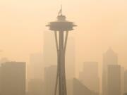 FILE - In this Sept. 11, 2020, file photo, an American flag on top the Space Needle was lowered to half-staff today by the Seattle Fire Department to remember those who lost their lives on 9/11, Friday, Sept. 11, 2020. Thick smoke from wildfires burning across Washington, Oregon and California makes seeing the Space Needle and downtown Seattle nearly impossible in this view from Queen Anne Hill.