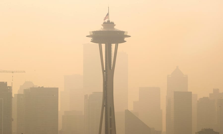 FILE - In this Sept. 11, 2020, file photo, an American flag on top the Space Needle was lowered to half-staff today by the Seattle Fire Department to remember those who lost their lives on 9/11, Friday, Sept. 11, 2020. Thick smoke from wildfires burning across Washington, Oregon and California makes seeing the Space Needle and downtown Seattle nearly impossible in this view from Queen Anne Hill.