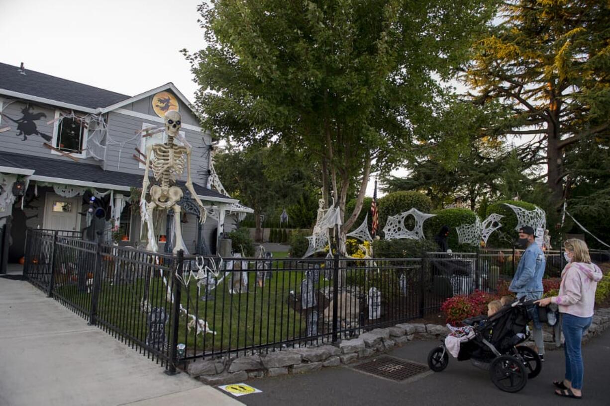 Alice and Lela Cummings, 3 and 5, and their parents, Dave and Meghaan, admire Jim and Ceci Mains&#039; Halloween extravaganza in west Vancouver. This year the Mainses have built a 20-foot candy chute into their design in order to get sweets into kid&#039;s hands.