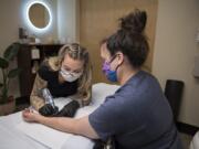 Lina Anderson of Studio Meraki works with Gwen McClellan of Vancouver as she gets the first of two scar camouflage treatments in Portland. They are self-harm scars from her teenage years. Anderson has used the camouflage treatment to help people with self-harm scars.