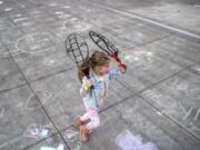 Lylah Bloom, 6, plays outside during the after-school program at Firstenburg Community Center in Vancouver. Below, Cash Mendoza, 6, sports a cat mask at the after-school program at Firstenburg Community Center in Vancouver.