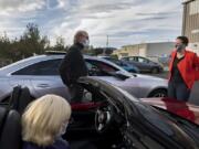 Jo Ellen Jarvis and Dave Watson wear masks while getting a few minutes to chat with congressional candidate Carolyn Long before a drive-in town hall in Washougal on Monday.