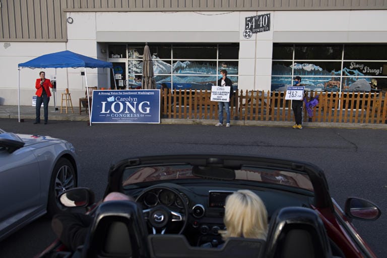 Congressional candidate Carolyn Long, from left, speaks to voters in Washougal during a drive-in town hall while joined by supporters Riley Coler and Joe-Henry McQuary on Monday evening, Oct. 12, 2020.