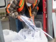 Elections worker John Waterbury collects ballots from an official ballot drop box Saturday in downtown Vancouver.