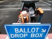 Elections workers John Waterbury, left, and Les Stark collect ballots from an official drop box near the Clark County Elections Office on Saturday morning, October 17, 2020.