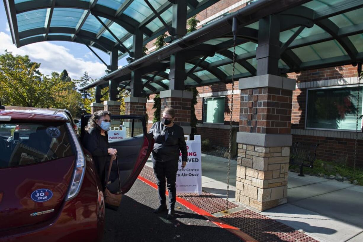 Bennye Wright of Vancouver exits the car with the help of Connie Pickering of the Human Services Council as she arrives for her appointment at The Vancouver Clinic on Wednesday afternoon. Both demand for rides and the number of volunteer drivers have been reduced during the pandemic.