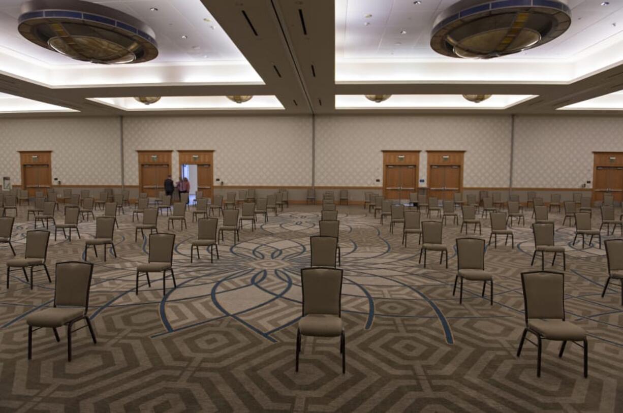 Staff at the Hilton Vancouver Washington prepare for an upcoming socially distanced meeting. The hotel is starting to see some meetings return to its convention center, Mike McLeod said, the hotel&#039;s general manager. It has allowed the venue staff to hire some banquet workers back who were furloughed.