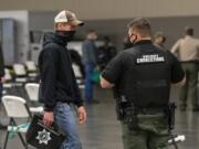 Zach Nygaard, left, speaks with a deputy in a socially distanced seating area during a recruitment event for Clark County Jail corrections deputies Tuesday evening at the Clark County Event Center at the Fairgrounds.