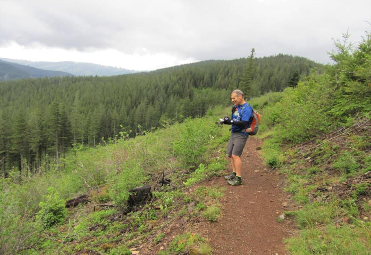 Guidebook author Craig Romano takes notes while hiking the Yacolt Burn State Forest&#039;s Tarbell Trail.