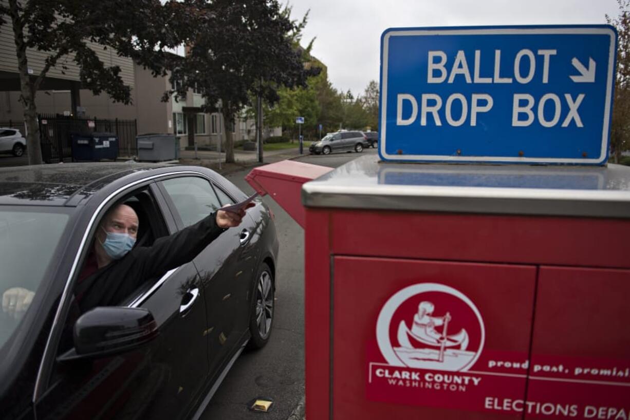 Ridgefield resident Anthony Bilic wears a protective mask as he gets his vote in early at a downtown Vancouver ballot drop box Thursday afternoon. Bilic was among a steady stream of voters who came out on Thursday in advance of next week&#039;s election.