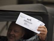 Vancouver resident Larry Hellstrom displays his ballot before dropping it off Thursday afternoon in downtown Vancouver.