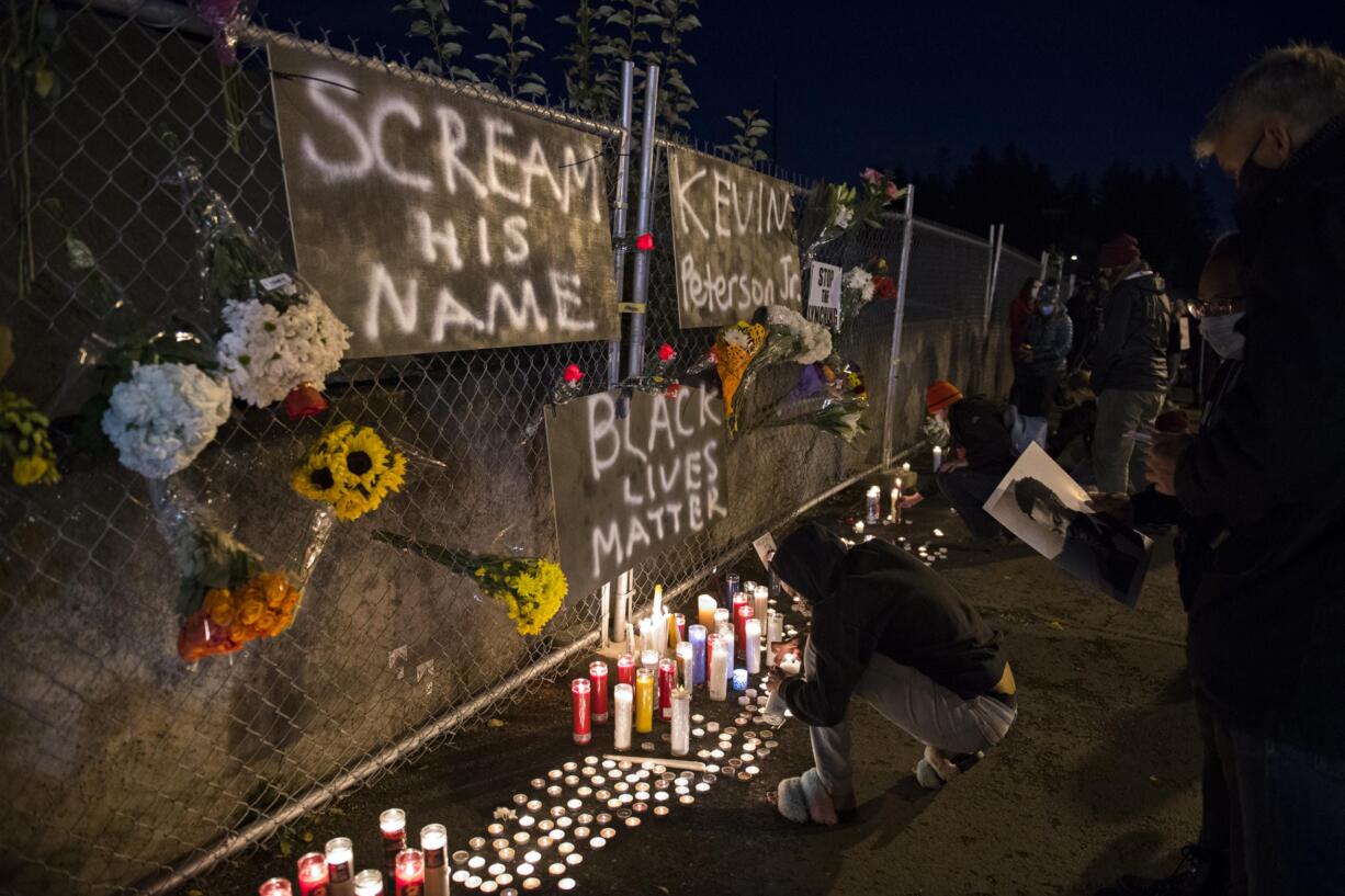 Portland resident Queasajney Jackson pauses to honor the memory of Kevin Peterson Jr., a 21-year-old Black Camas man, as he is remembered with a candlelight vigil at the Hazel Dell branch of U.S. Bank on Friday night, Oct. 30, 2020.