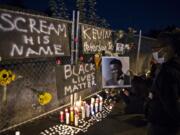 Alisha, one of the event organizers who declined to give her last name, holds a photo of Kevin Peterson Jr., a 21-year-old Black Camas man who was killed Thursday, as he is remembered with a candlelight vigil at the Hazel Dell branch of U.S. Bank on Friday night, Oct. 30, 2020.