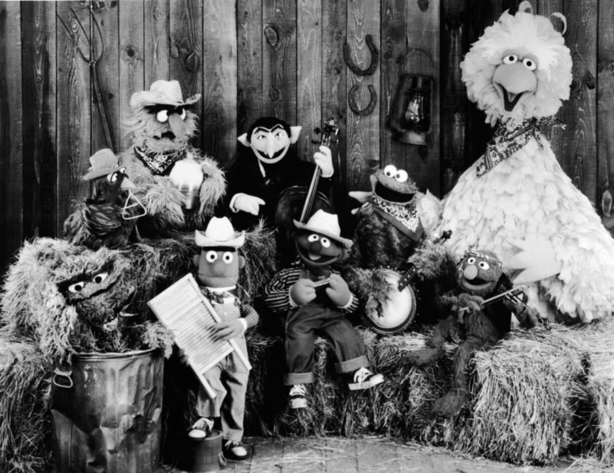 Publicity still of the Sesame Street Muppets taken to promote their record album, &#039;Sesame Country,&#039; July 1, 1981. Included are Oscar the Crouch (in garbage can), Bert (holding washboard), Ernie (harmonica), the Count (bass), Cookie Monster (banjo), Grover (violin), and Big Bird (far right).