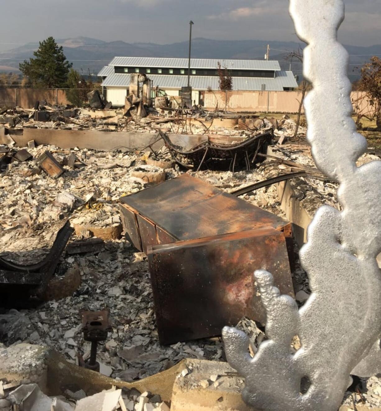 Scott Balcom rescued this melted piece of aluminum  from a nearby street and stuck beside his house destroyed by the Almeda fire as a symbol of renewal. He surmises the aluminum came from a car caught up in the fire&#039;s fierce heat.