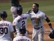 Houston Astros&#039; Carlos Correa, right, celebrates after hitting a three-run home run that scored Kyle Tucker (30) and Alex Bregman (2) during the fourth inning of Game 4 of a baseball American League Division Series against the Oakland Athletics in Los Angeles, Thursday, Oct. 8, 2020.