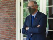 Washington Gov. Jay Inslee pauses on a walkway outside the Governor's Mansion after taking part in an AP interview, Friday, Sept. 25, 2020, in Olympia. (AP Photo/Ted S.