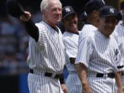 Former New York Yankees pitcher, Whitey Ford, left, acknowledges the crowd during introductions as Yogi Berra, right looks on before the Old Timers game in 2007 at Yankee Stadium in New York. A family member tells The Associated Press on Friday, Oct. 9, 2020 that Ford died at his Long Island home Thursday night.