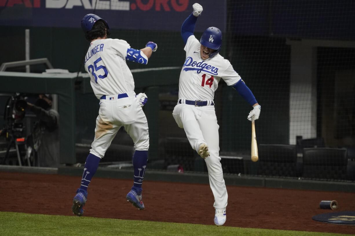 Los Angeles Dodgers' Cody Bellinger celebrates his home run with Enrique Hernandez against the Atlanta Braves during the seventh inning in Game 7 of a baseball National League Championship Series Sunday, Oct.