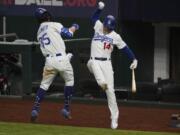 Los Angeles Dodgers' Cody Bellinger celebrates his home run with Enrique Hernandez against the Atlanta Braves during the seventh inning in Game 7 of a baseball National League Championship Series Sunday, Oct.