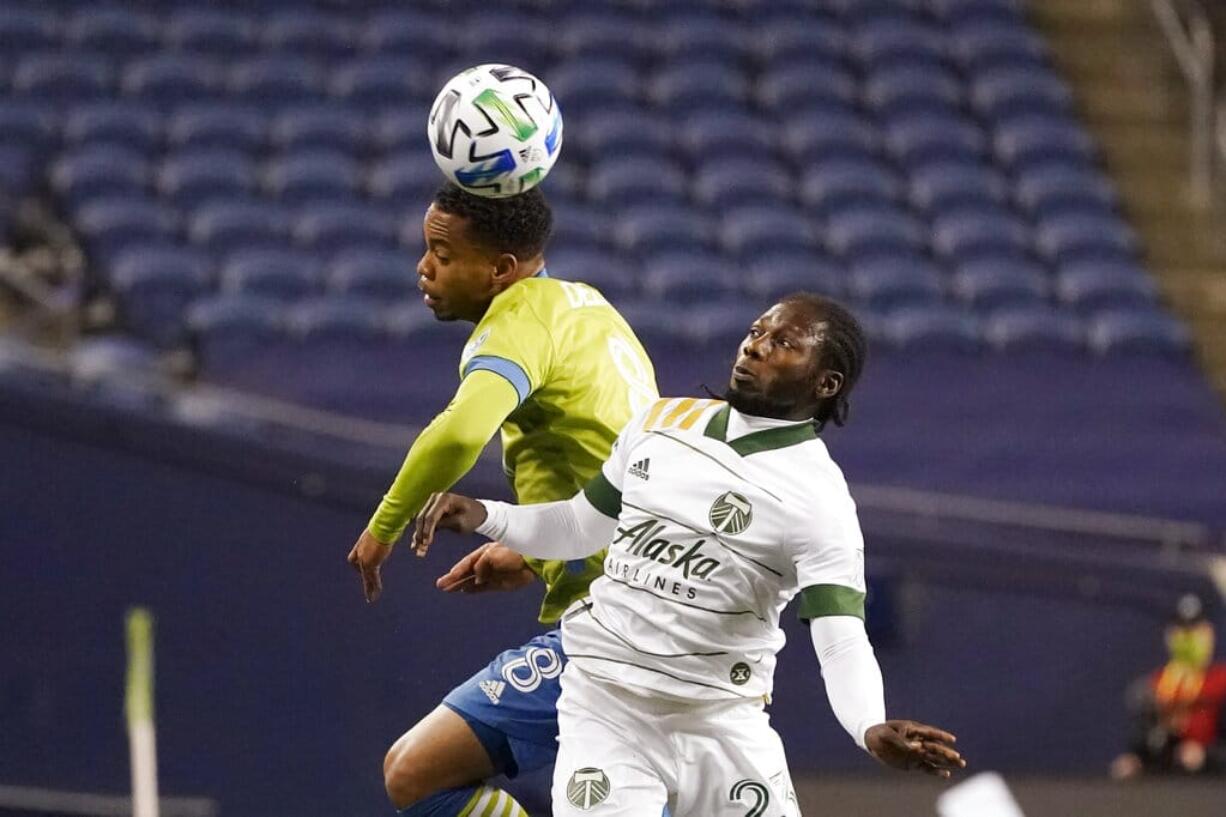 Seattle Sounders' Jordy Delem (8) heads the ball in front of Portland Timbers' Yimmi Chara in the first half of an MLS soccer match, Thursday, Oct. 22, 2020, in Seattle.