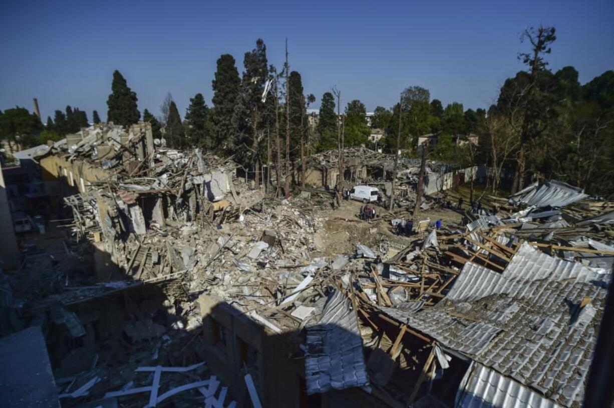 People look at the destroyed houses a day after shelling by Armenian&#039;s artillery during fighting over the separatist region of Nagorno-Karabakh, in Ganja, Azerbaijan, Monday, Oct. 12, 2020. Armenia and Azerbaijan on Monday have accused each other of attacks over the separatist territory of Nagorno-Karabakh despite a cease-fire deal brokered by Russia in an effort to end the worst outbreak of hostilities in decades.