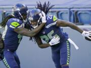 Seattle Seahawks cornerback Shaquill Griffin (26) is greeted by his twin brother, outside linebacker Shaquem Griffin (49), after Shaquill Griffin intercepted a pass against the Dallas Cowboys during the first half of an NFL football game, Sunday, Sept. 27, 2020, in Seattle.