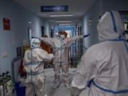 A medical team member is disinfected before leaving the COVID-19 ward at the Severo Ochoa hospital in Leganes, outskirts of Madrid, Spain, Friday, Oct. 9, 2020. At the peak of the first wave, ICU wards were given over to haste, desperation and even cluelessness about what to do. Now, a well-oiled machinery saves some lives and loses others to coronavirus, but without the doomsday atmosphere of March and April.