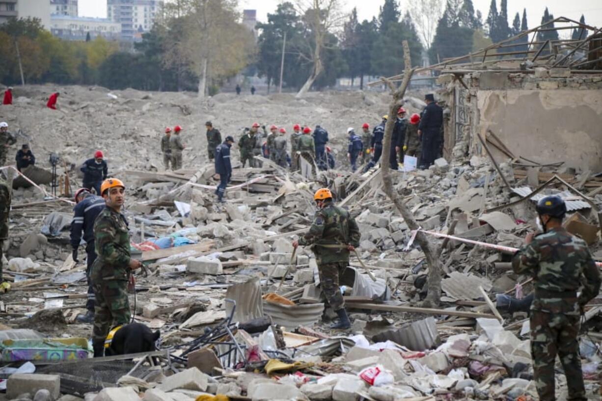 Soldiers and firefighters search for survivors in a residential area that was hit by rocket fire overnight by Armenian forces, early Saturday, Oct. 17, 2020, in Gyanga, Azerbaijan&#039;s second largest city, near the border with Armenia.