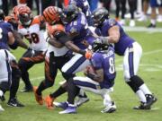 Cincinnati Bengals defensive end Carlos Dunlap (96) is able to sack Baltimore Ravens quarterback Lamar Jackson (8) in spite of being blocked by Ravens offensive tackle Orlando Brown (78) during the first half of an NFL football game, Sunday, Oct. 11, 2020, in Baltimore.