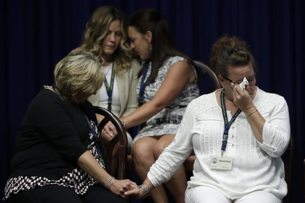 FILE - In this Aug. 14, 2018 file photo, victims of clergy sexual abuse, or their family members, react as Pennsylvania Attorney General Josh Shapiro speaks during a news conference at the State Capitol in Harrisburg, Pa. The child-protection policies adopted by Roman Catholic leaders to curb clergy sex abuse in the U.S. are inconsistent and often worryingly incomplete, according to the Philadelphia-based CHILD USA think tank&#039;s 2018-2020 investigation of policies in all 32 archdioceses.