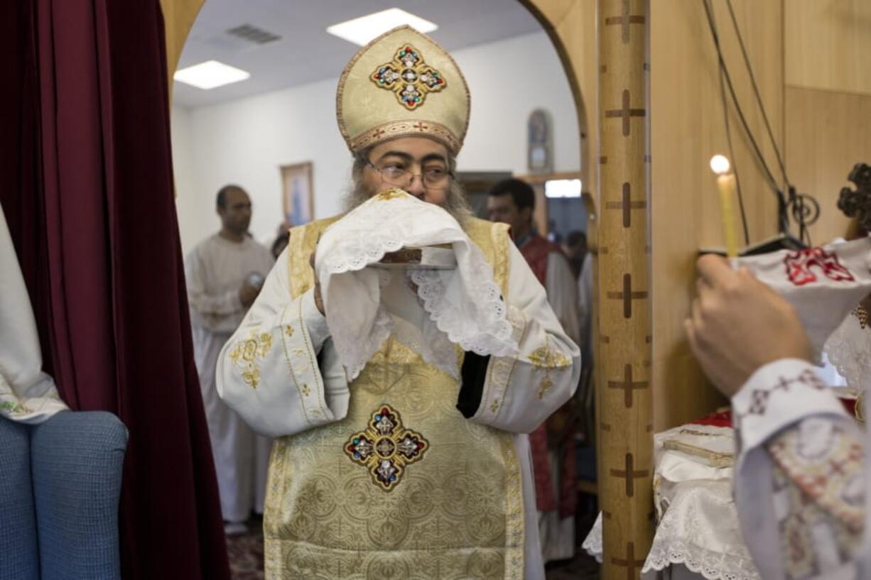 In this Sunday, Aug. 18, 2013 photo, Father Reweis Khalil brings the bread (Body of Christ) to worshippers during Sunday service at St. George Coptic Orthodox Church in Hampton, VA., on Sunday, Aug. 18, 2013. Khalil was removed from the priesthood in July. Sally Zakhari has alleged, including in a police report and to Coptic Church officials, that Khalil has sexually abused her. Khalil has denied the allegations through his attorney. (The&#039; N.