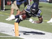 Seattle Seahawks running back Chris Carson (32) dives near the end zone during the first half of an NFL football game against the Dallas Cowboys, Sunday, Sept. 27, 2020, in Seattle. The Seahawks won 38-31.