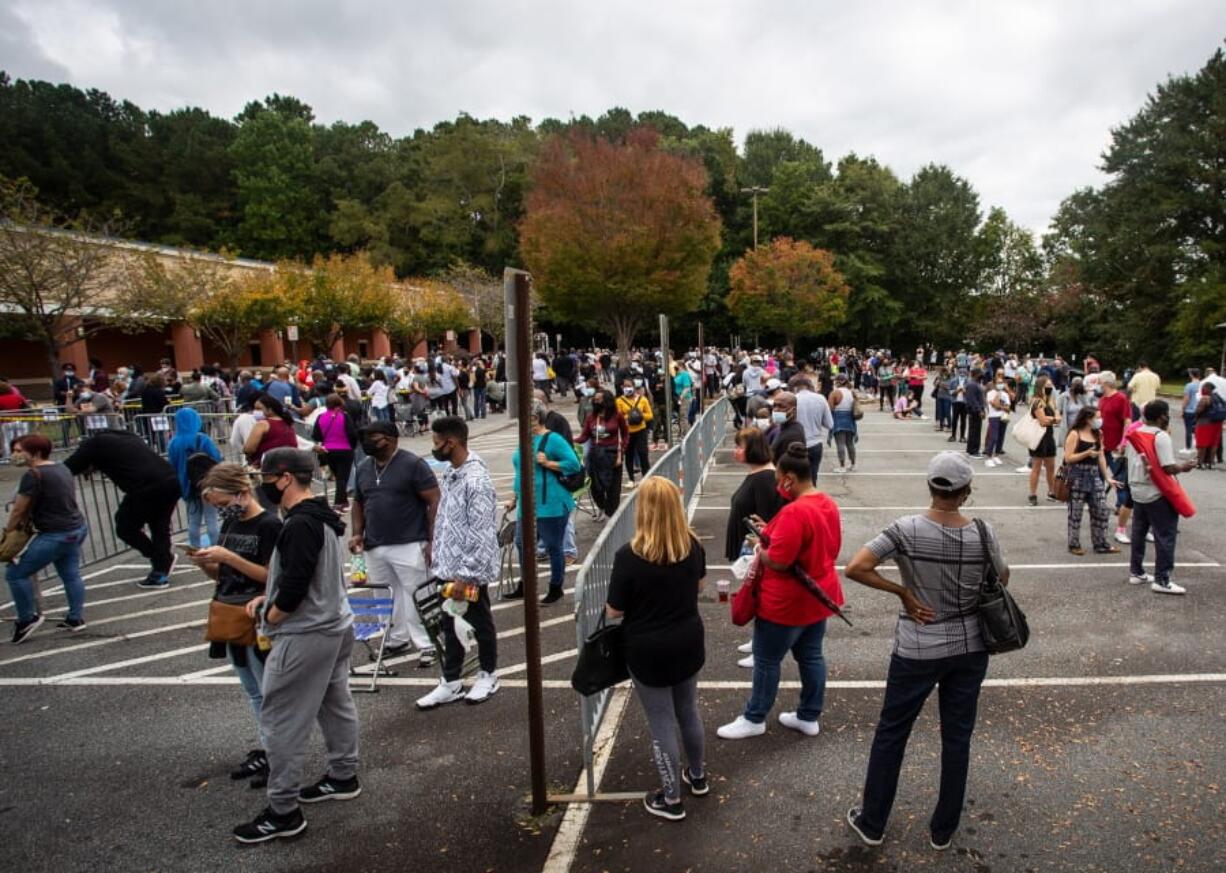 Hundreds of people wait in line for early voting on Monday, Oct. 12, 2020, in Marietta, Georgia. Eager voters have waited six hours or more in the former Republican stronghold of Cobb County, and lines have wrapped around buildings in solidly Democratic DeKalb County.