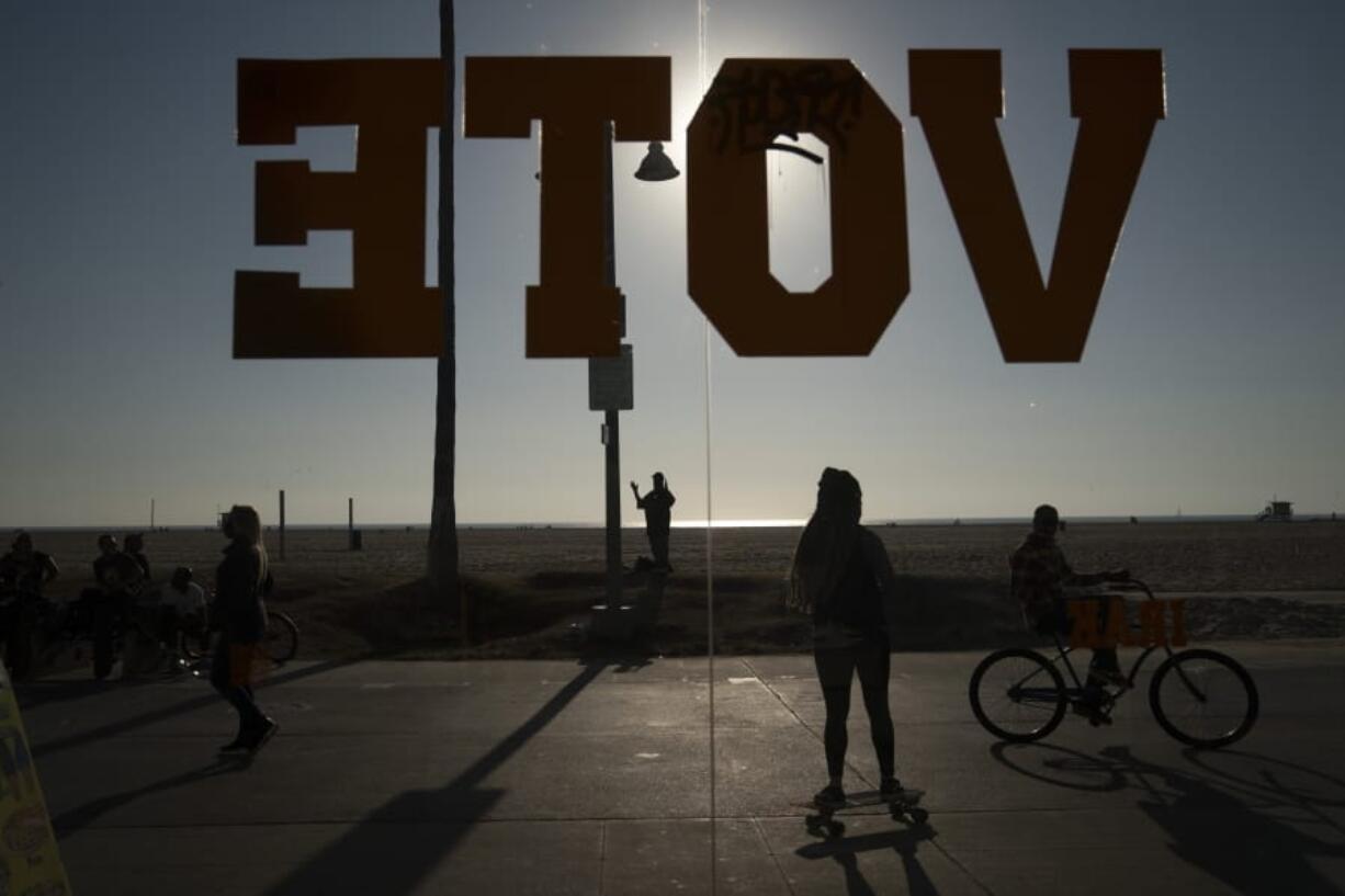 A vote sign is posted on the window of a shoe store on the Venice Beach Boardwalk in Los Angeles, Wednesday, Oct. 28, 2020. (AP Photo/Jae C.