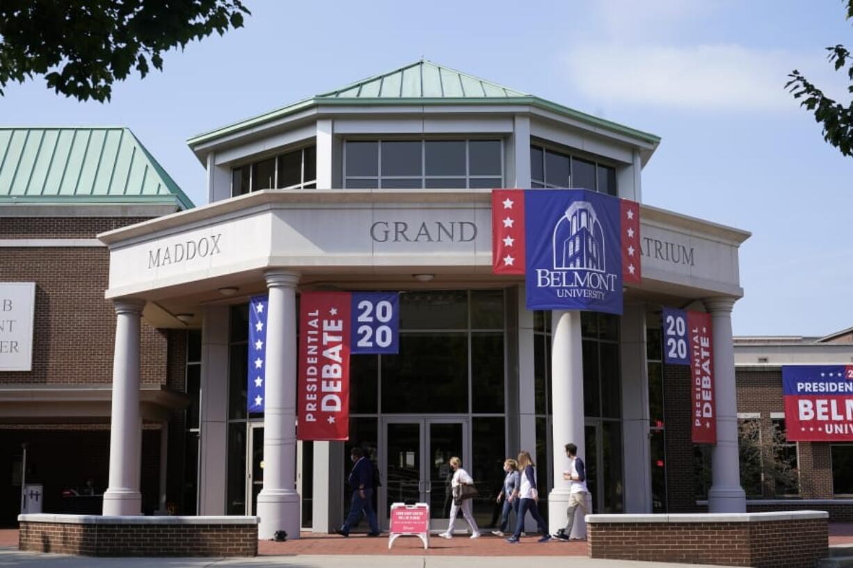 People walk outside the Curb Event Center at Belmont University as preparations take place for the second Presidential debate, Tuesday, Oct. 20, 2020, in Nashville, Tenn. President Donald Trump and Democratic presidential candidate, former Vice President Joe Biden are scheduled to debate Thursday, Oct. 22.