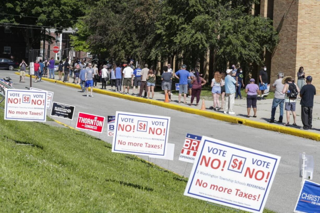 FILE - In this June 2, 2020 file photo, voters wait in a line outside Broad Ripple High School to vote in the Indiana primary in Indianapolis. Indiana election officials are bracing for perhaps 10 times more mail-in ballots for this fall&#039;s election than four years ago. The secretary of state office&#039;s projection of 1.3 million to 1.8 million mailed ballots means more than half of Indiana&#039;s voters might choose that option rather than heading to polling sites for the Nov.