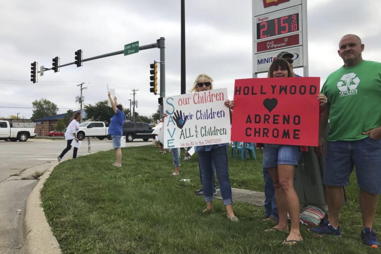 A group holds signs rallying in support of the &quot;Save the Children&quot; movement, calling for an end to child trafficking Sept. 26, 2020, in Morris, Ill. Conversations about &quot;Save the Children&quot; have spiked on social media in recent months and some supporters have taken to city and suburban streets across the U.S. to promote their new cause. Their catchphrase was first made popular online by conspiracy theorists promoting QAnon.