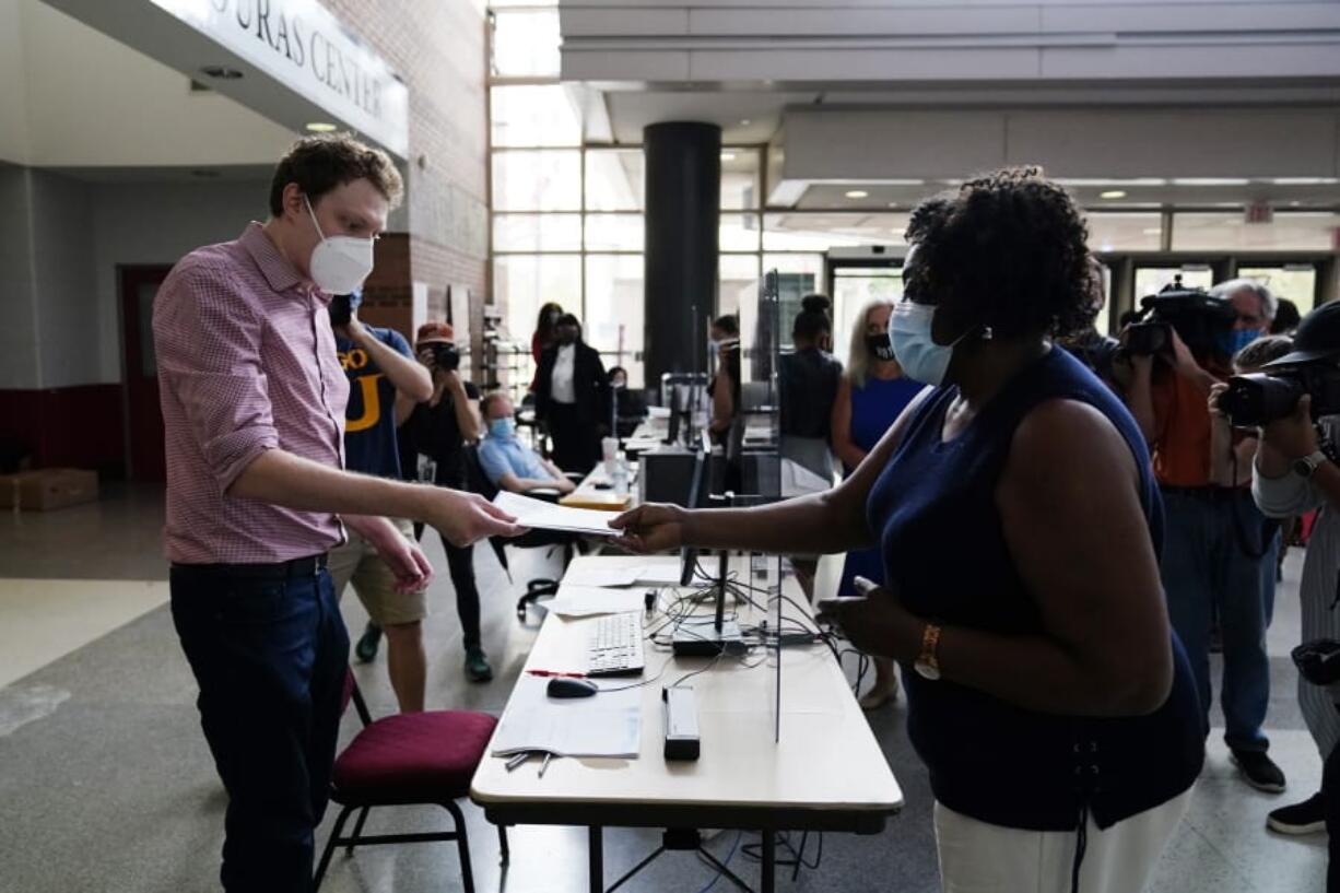 Philadelphia resident Priscilla Bennett receives her mail-in ballot at the opening of a satellite election office at Temple University&#039;s Liacouras Center, on Sept. 29, 2020, in Philadelphia.  Pennsylvania is one of this year&#039;s most hotly contested battleground states and also is facing a flurry of lawsuits, complaints and partisan finger-pointing over its election procedures and systems.