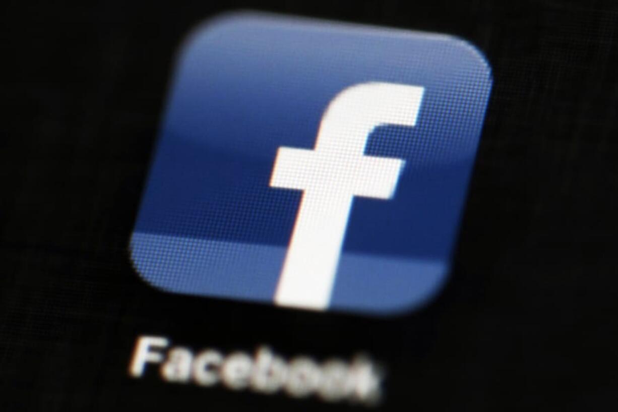 FILE - This May 16, 2012 file photo shows the Facebook app logo on a mobile device in Philadelphia. On Monday, Oct. 12, 2020, Facebook announced it is banning posts that deny or distort the Holocaust and will start directing people to authoritative sources if they search for information about the Nazi genocide.