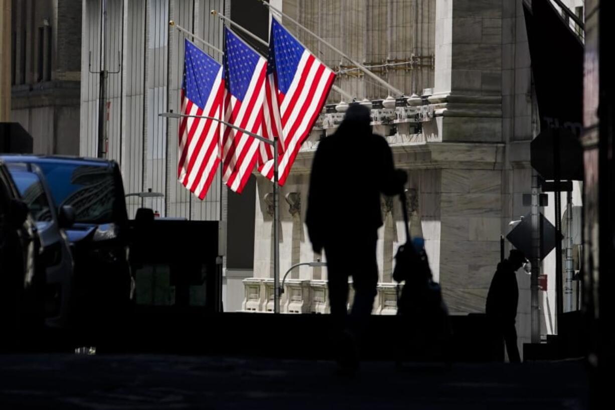 FILE - In this Oct. 14, 2020 file photo, pedestrians pass the New York Stock Exchange in New York. Stocks are opening higher on Wall Street Tuesday, Oct. 20 as traders look over several solid earnings reports from U.S. companies.