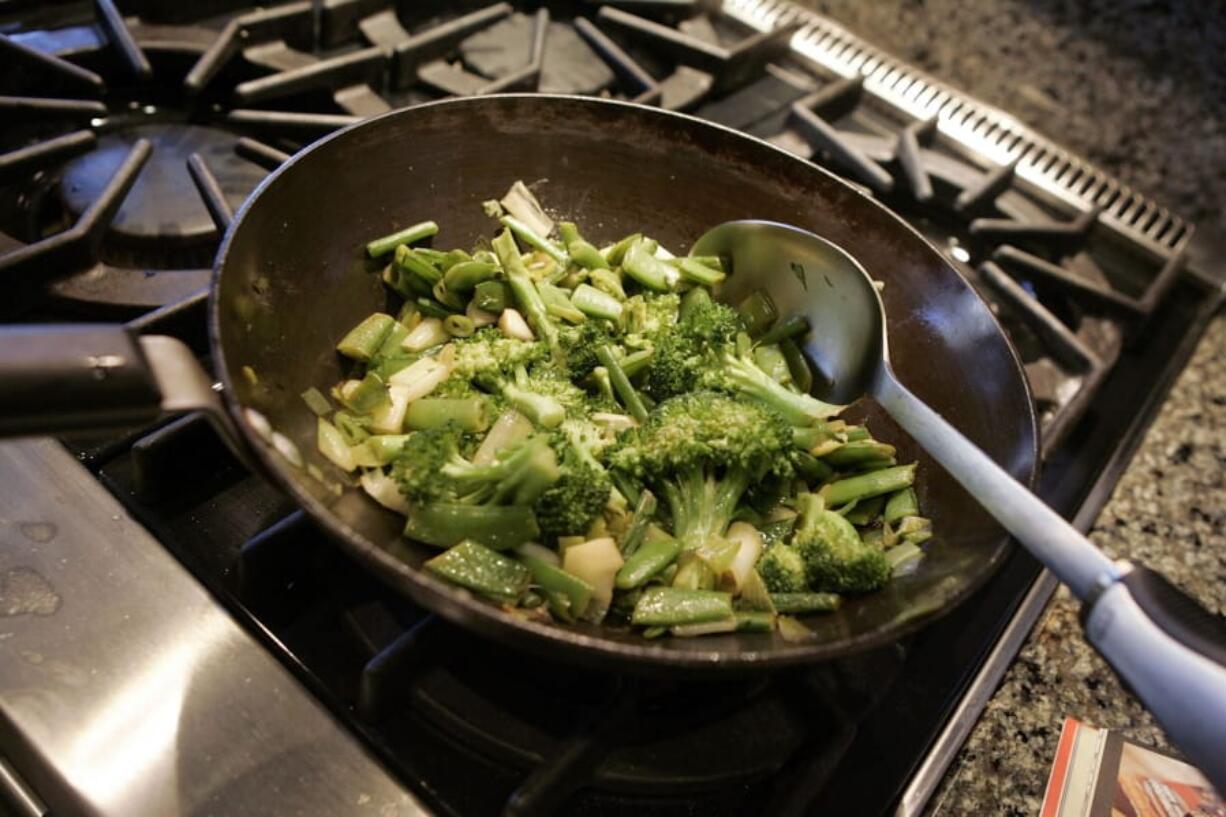 FILE - This Aug. 5, 2006 file photo shows a vegetable stir fry dish being prepared in New York. Stir-fry technique has many people intimidated. But if you can slice and stir, you can stir fry.