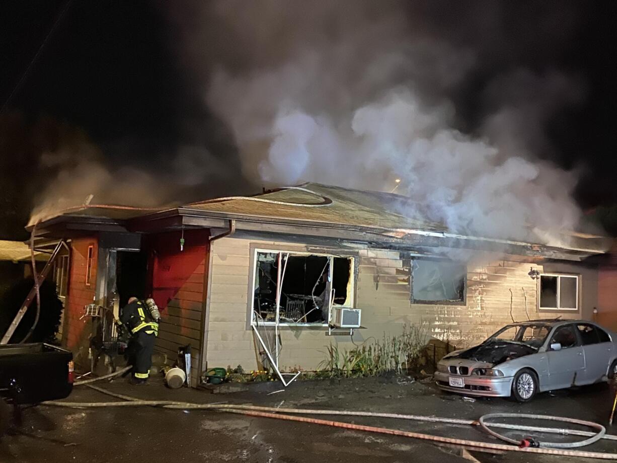 Firefighters work at the scene of a stubborn fire at 6205 N.E. 11th Ave. in Hazel Dell. Seven people were displaced by the fire.