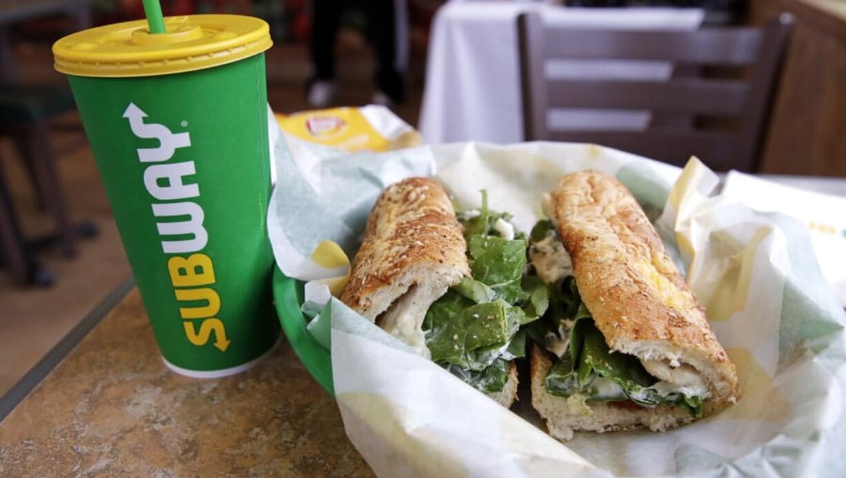 FILE - In this Friday, Feb. 23, 2018 file photo, the Subway logo is seen on a soft drink cup next to a sandwich at a restaurant in Londonderry, N.H.. Ireland&#039;s Supreme Court has ruled that bread sold by the fast food chain Subway contains so much sugar that it cannot be legally defined as bread.