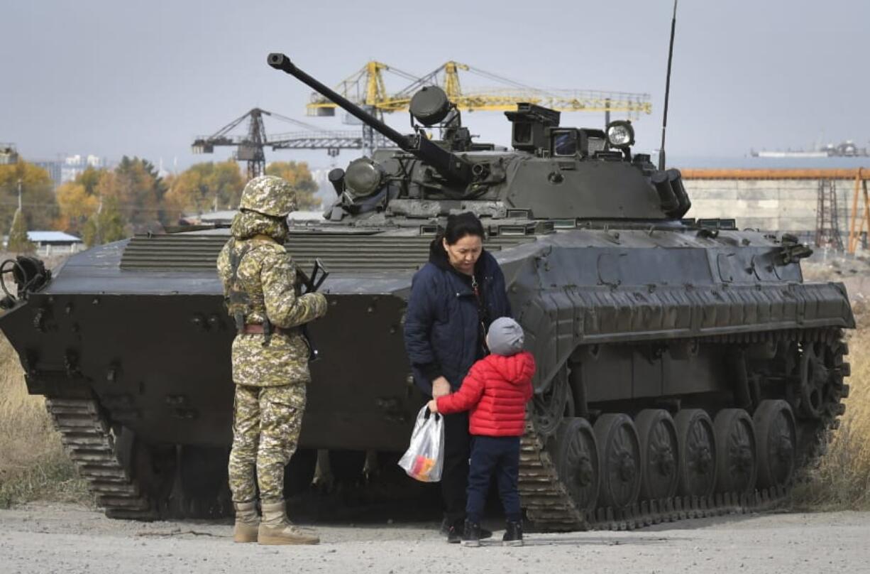 Soldiers of Kyrgyz army stand at checkpoint on city street in Bishkek, Kyrgyzstan, Saturday, Oct. 10, 2020. President Sooronbai Jeenbekov decreed the state of emergency in the capital and ordered the military to deploy troops to Bishkek to enforce the measure.