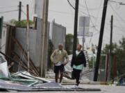 Tourists walk past debris littering the street after Hurricane Zeta&#039;s landfall in Playa del Carmen, Mexico, early Tuesday, Oct. 27, 2020. Zeta is leaving Mexico&#039;s Yucatan Peninsula on a path that could hit New Orleans Wednesday night.