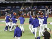 Los Angeles Dodgers players mob pitcher Julio Urias after they defeated the Atlanta Braves 4-3 in Game 7 of the National League Championship Series, Sunday in Arlington, Texas.